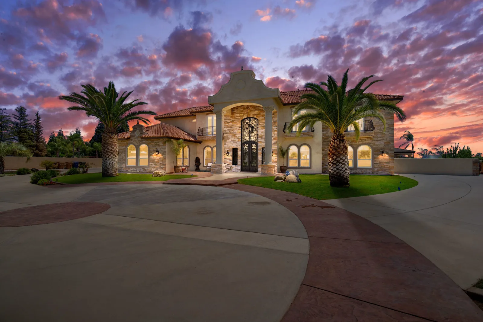 Twilight photograph of a luxury stone estate by Muyinza Kasirye